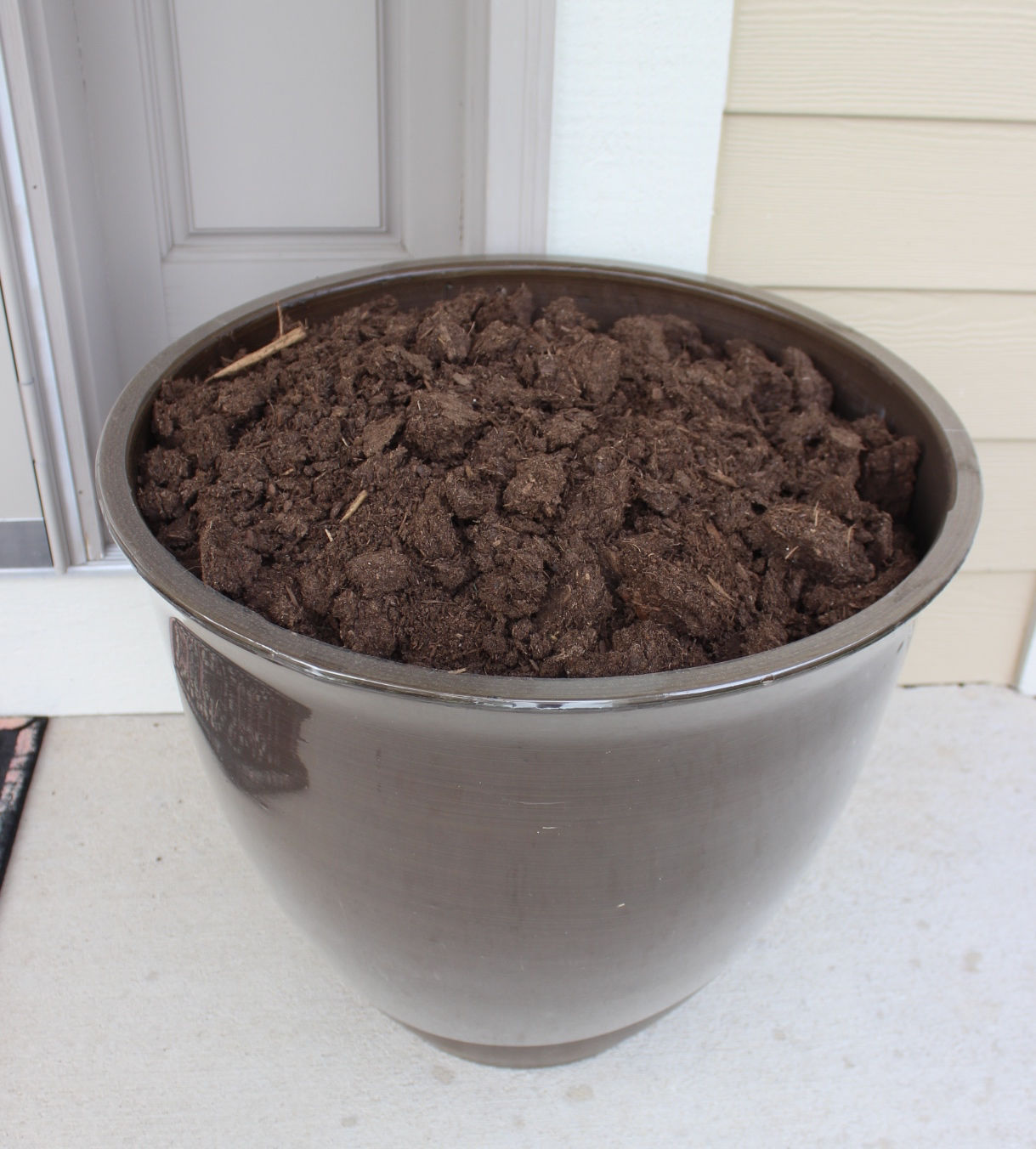 An outdoor planter filled with potting mix.