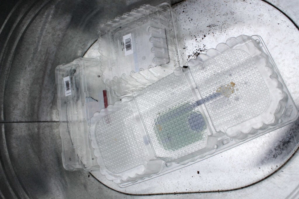 plastic containers are used to fill the bottom of a galvanized tub so you don't need to use as much soil.