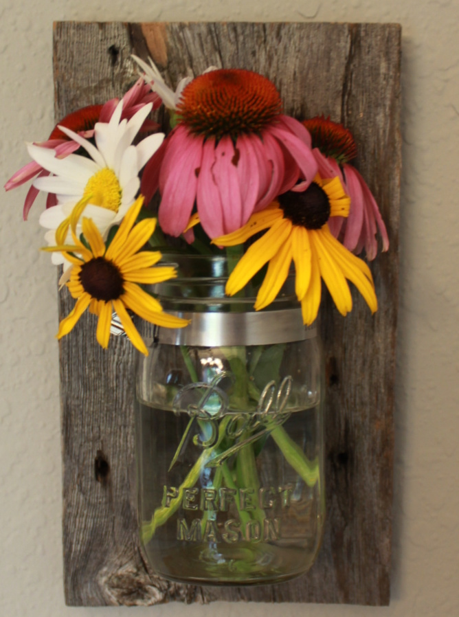 mason jar vase mounted on a piece of barnyard.